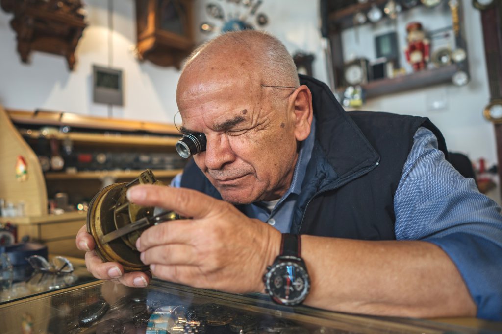a man inspecting an antique item (Attracting Designers Online)