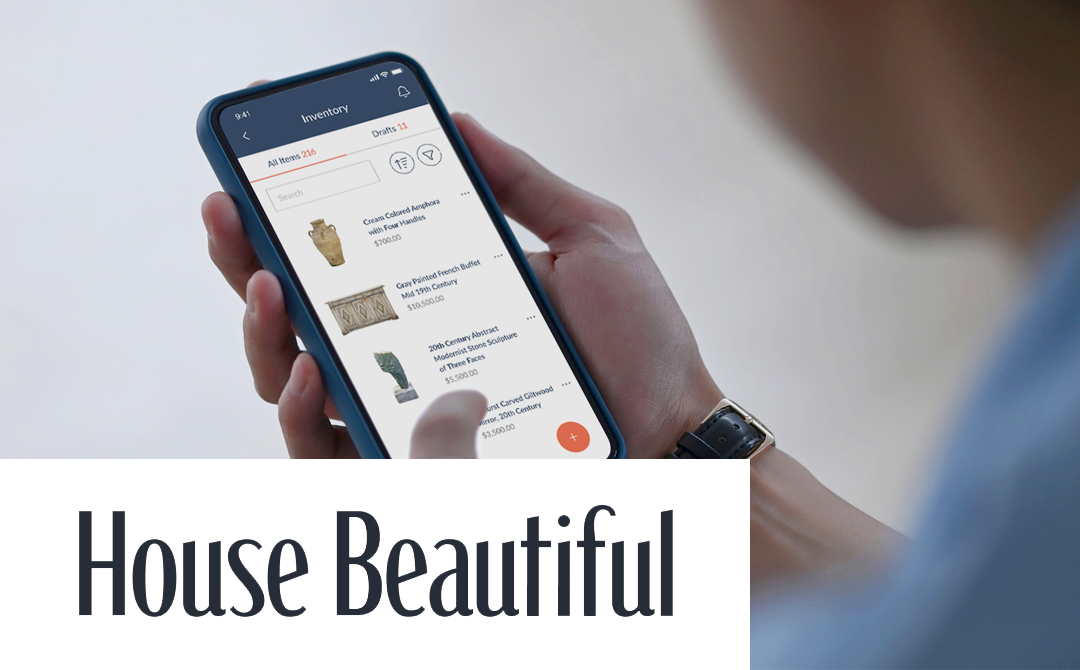 Close-up of a person's hand holding a smartphone displaying the Ronati mobile app inventory management interface. The screen shows antique items including a cream-colored amphora, a gray French buffet, and a modernist sculpture with their prices. The bottom right corner features the 'House Beautiful' logo in large, elegant typography, indicating Ronati's feature in the publication.