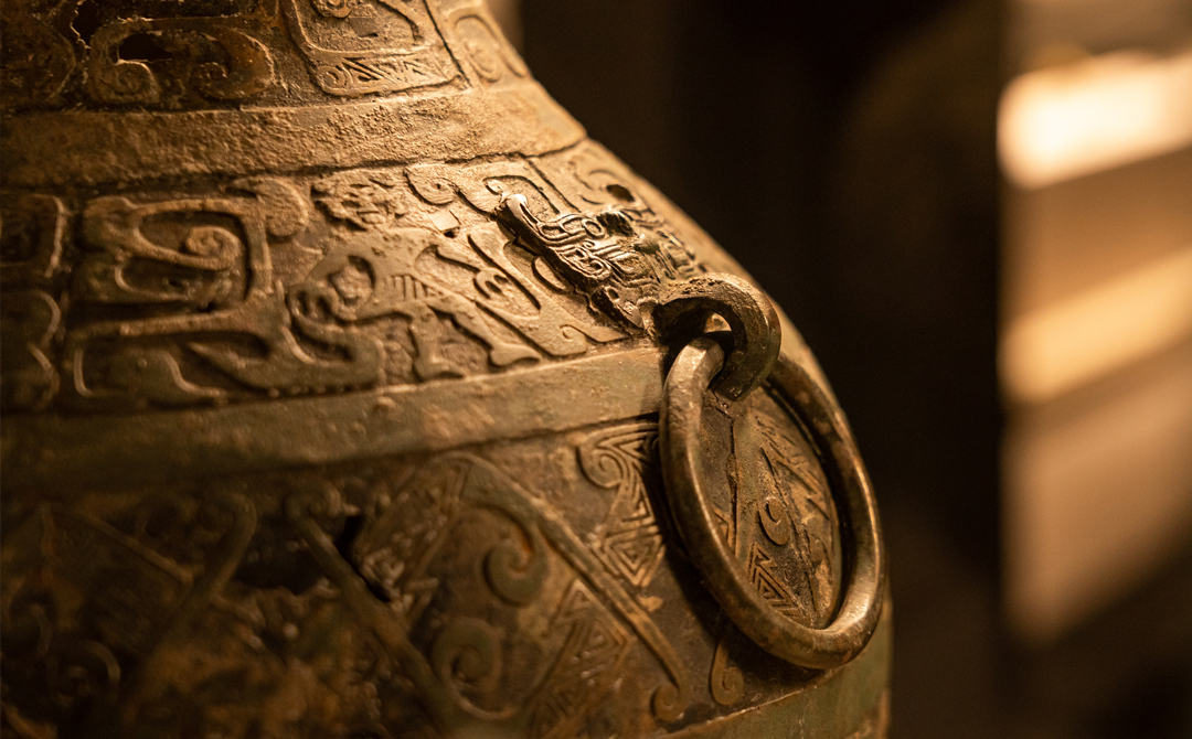 Detail of an engraved antique vessel, highlighting patina, surface wear, and craftsmanship often assessed by dealers at vintage and antiques fairs.