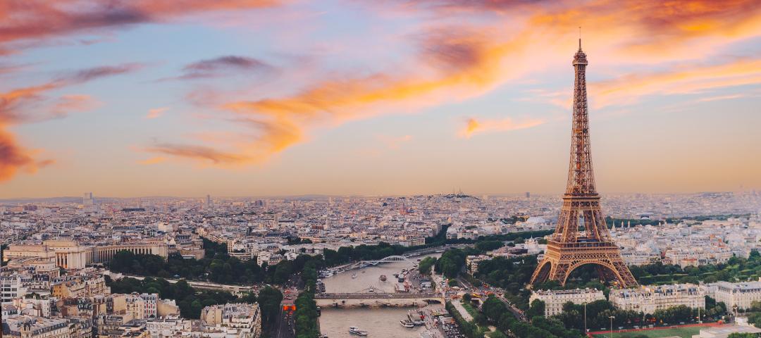 Alt text: Aerial view of Paris with the Eiffel Tower at sunset, symbolizing France’s role in the European antiques and design fair calendar.