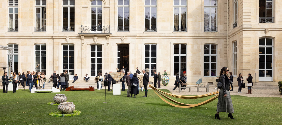 Collectors and design professionals gather on the lawn of a historic European residence during Design Miami Paris, where art, antiques, and contemporary works are presented in dialogue with architecture.