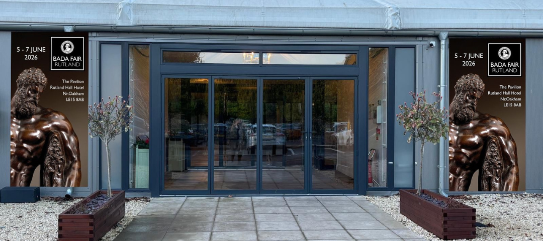 Entrance to the Pavilion at Rutland Hall Hotel with signage for the BADA Art & Antiques Fair Rutland, featuring event dates and branding on either side of the doors.