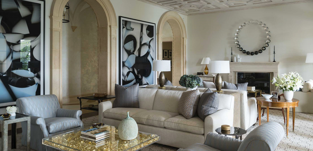 An elegant neutral-toned living room by David Kleinberg featuring arched architecture, sculptural contemporary art, and layered vintage textures inspired by the refined restraint of 1990s interiors.