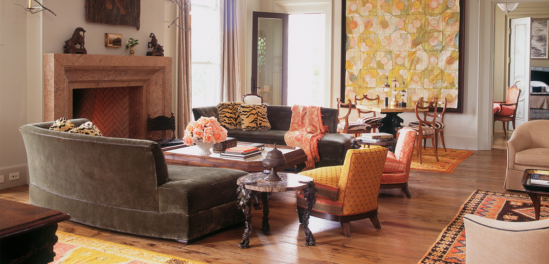 A warm, collected living room by Fisher Weisman Brugioni blending vintage furniture, rich textiles, sculptural antiques, and quiet architectural details in a layered interpretation of restrained 1990s-style interiors.