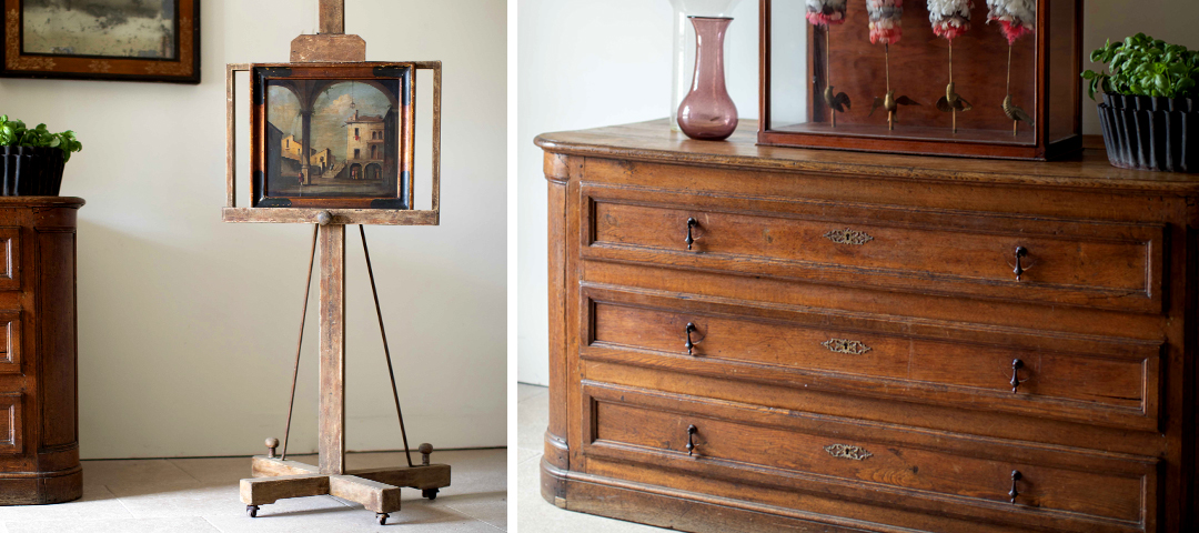 Antique Italian painting displayed on an easel beside a warm-toned wooden chest of drawers — illustrating the emotional resonance, patina, and lived material character that continue to draw collectors and designers toward historical objects in the digital age.