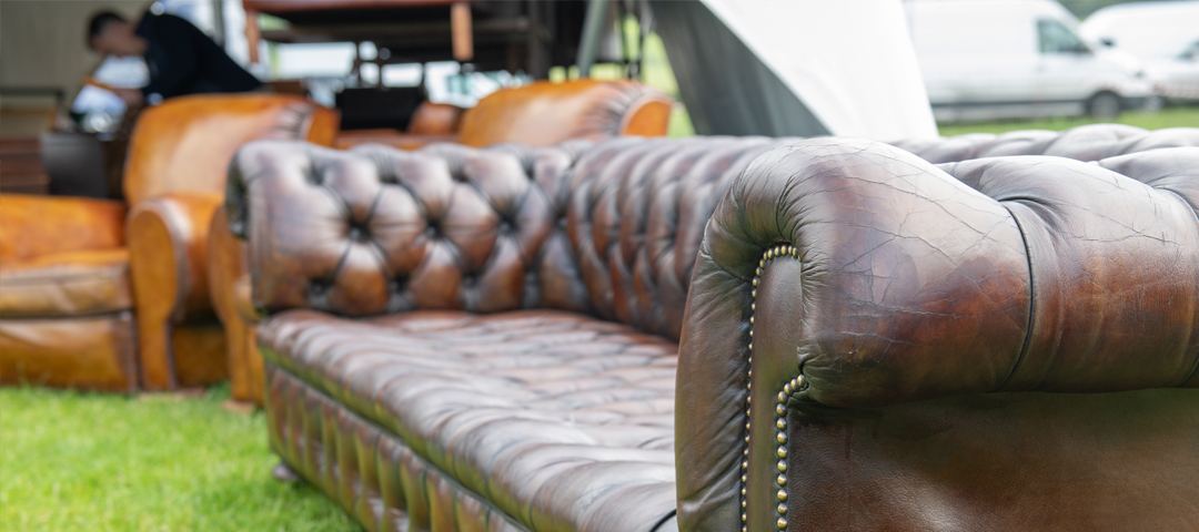 Close-up of a vintage leather Chesterfield sofa highlighting texture, patina, and craftsmanship