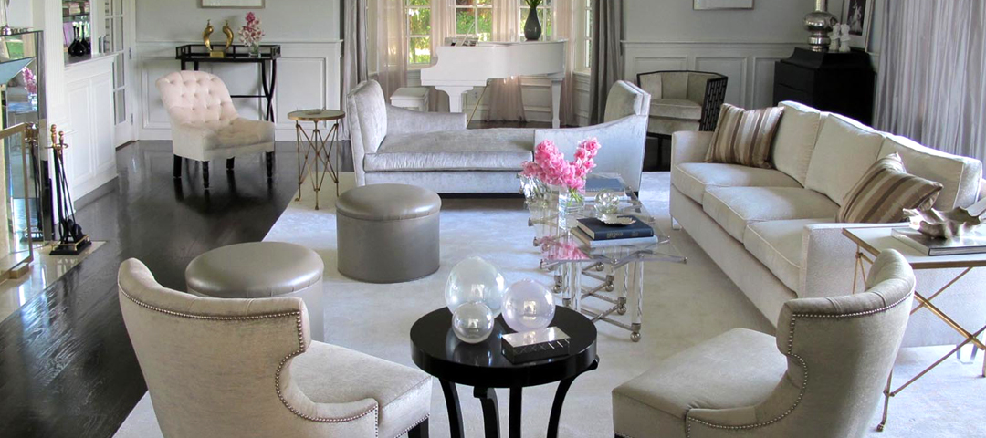 Living room by Michelle Workman in silvery-grey velvet with nailhead trim, lucite tables, and restrained Hollywood glamour.