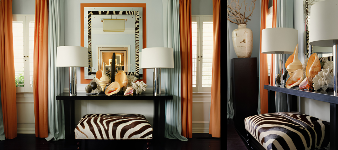 Entry with pale blue walls, orange and celadon silk curtains, a black console displaying conch shells and coral, and a zebra hide bench. Created by Mary McDonald.