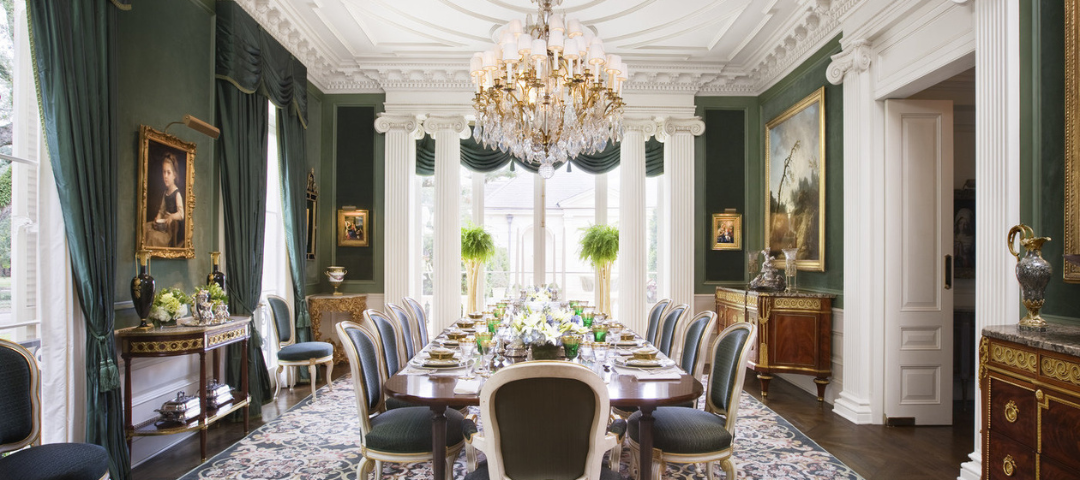 Alexa Hampton's deep green dining room, where medallion-back Louis XV–style chairs surround the table and a pair of ormolu-mounted mahogany commodes anchor the walls.