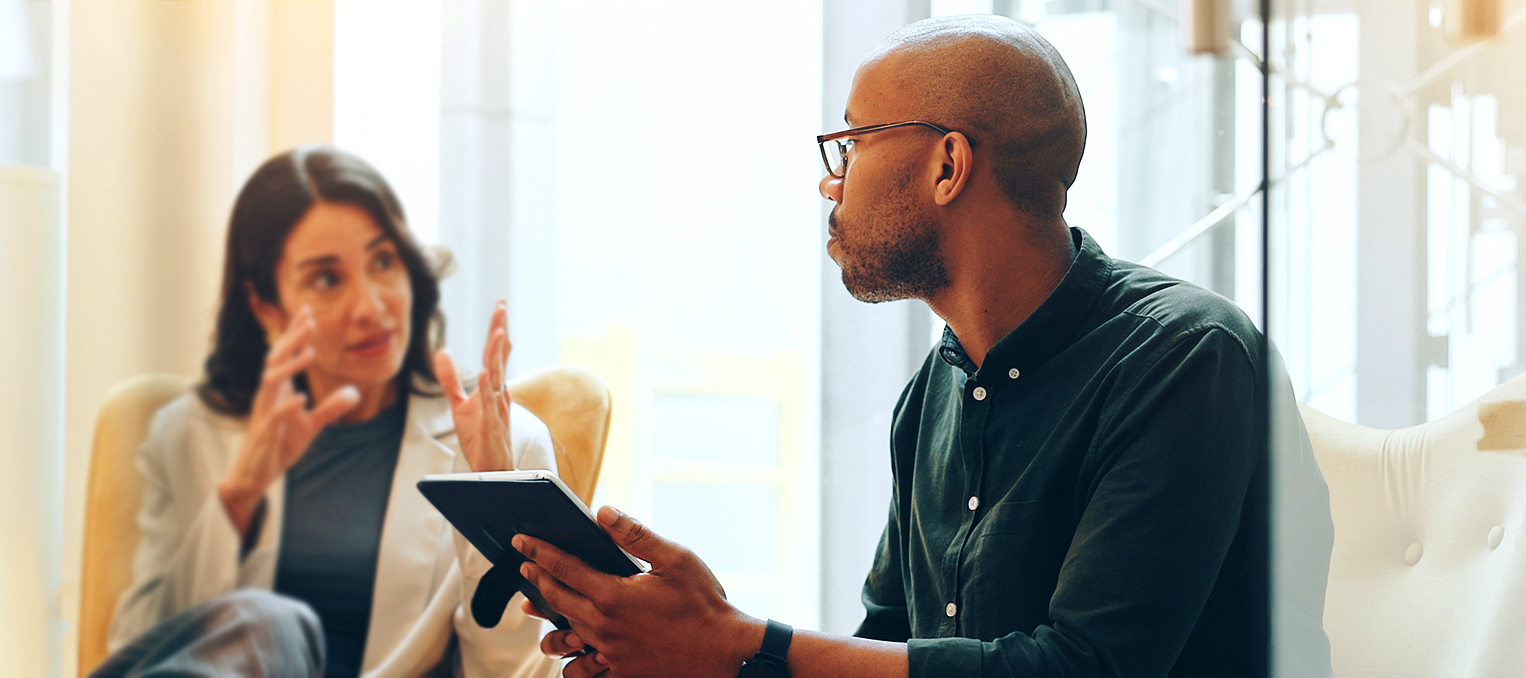 Dealer and client in conversation, referencing inventory on a tablet.