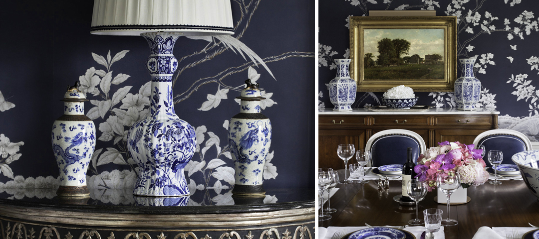 Blue and white porcelain vases and a lamp against navy chinoiserie wallpaper, beside a dining room with a gilt-framed landscape.